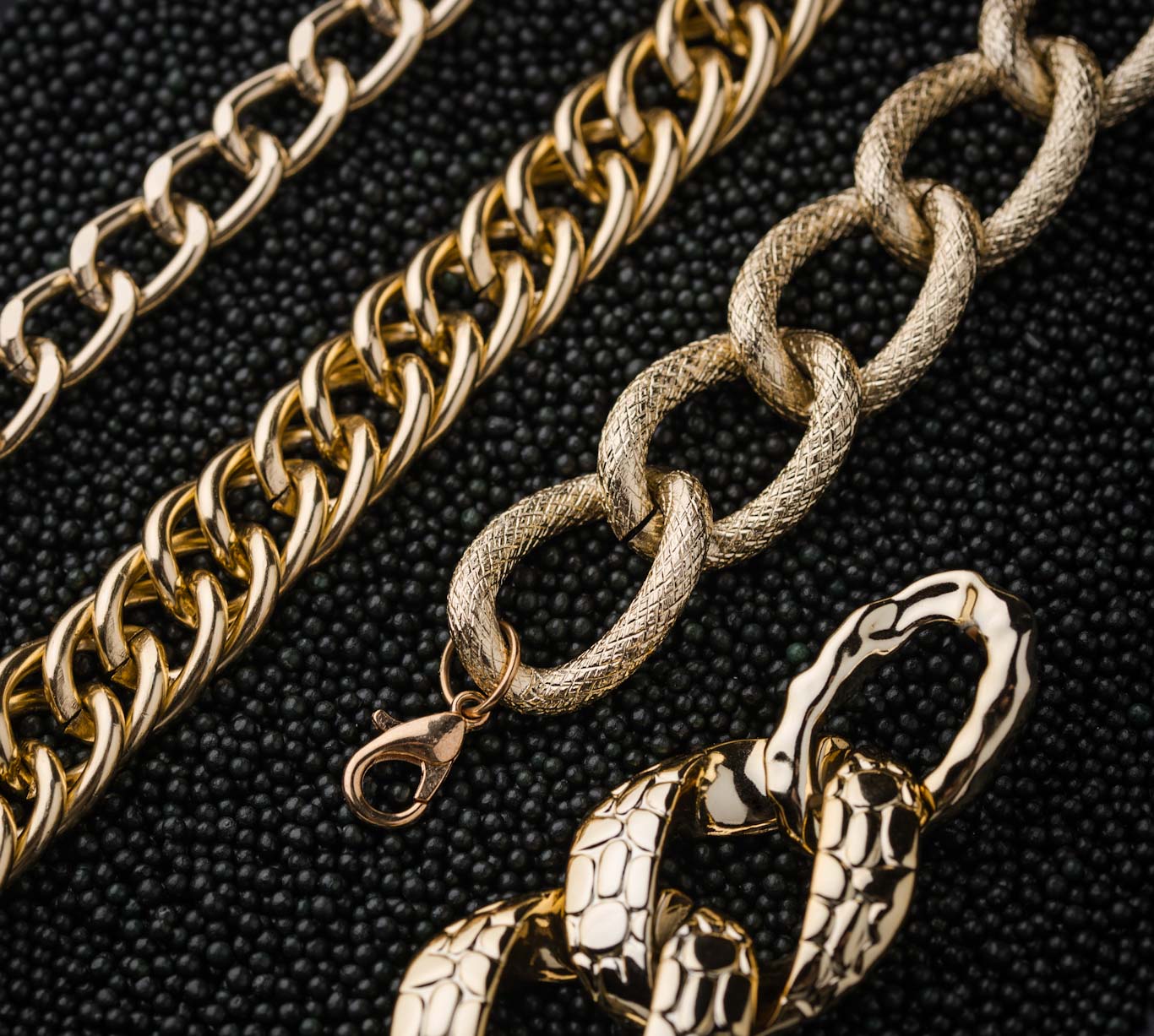 4 styles of gold chains laying on a black background pictured from top down close up high focus high res