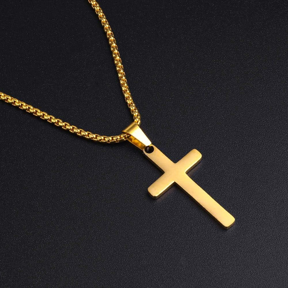 gold plated cross necklace pictured from the top down while the necklace lays on a black background